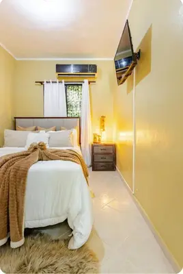 a bedroom with a bed and a tv on the wall at mini apartamento in Colorado