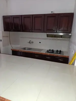 a kitchen with wooden cabinets and a sink at acuario residencial 2 in La Viva