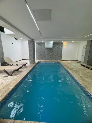a large swimming pool with blue water in a room at Apartamento Santo Domingo este in Juan López