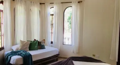 a bedroom with two beds and a window at Desconéctate de la civilización in Nagua