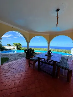 a porch with a table and a view of the ocean at Desconéctate de la civilización in Nagua