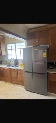 a kitchen with a stainless steel refrigerator and a sink at The Garcias Village C with Jacuzzi ACNetflix in La Alianza