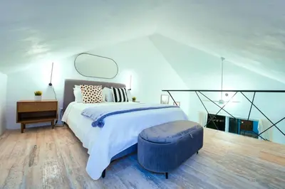 a bedroom with a large bed with a blue ottoman at Cana Brava Residences Rental Apartment Punta Cana in Punta Cana