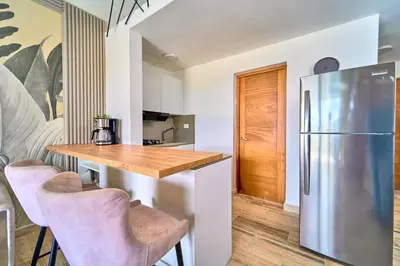 a kitchen with a wooden table and a refrigerator at Cana Brava Residences Rental Apartment Punta Cana in Punta Cana
