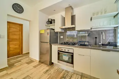 a kitchen with white cabinets and a stove top oven at Cana Brava Residences Rental Apartment Punta Cana in Punta Cana