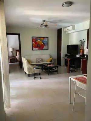 a living room with a couch and a table at Infiniti blu beautiful apartment at the pool in Sosúa