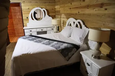 a bedroom with a white bed and a mirror at Villa Claudia Constanza in Arroyo Frío