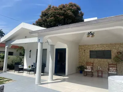 a white house with a stone wall at Your best escape in Dominican Republic!! in Santiago de los Caballeros