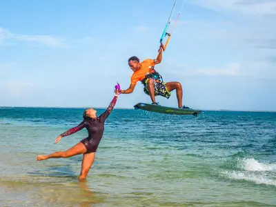 two people are jumping in the water on the beach at Buen Hombre Kite School with Accommodations in La Costa de Buen Hombre