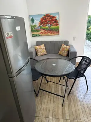 a living room with a couch and a table and a refrigerator at Damaris Bed & Breakfast in Las Terrenas