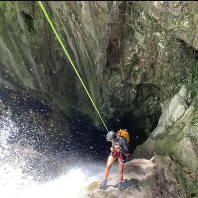 a man is on a rock in a river at Cabañas en las Montañas in San Cristóbal