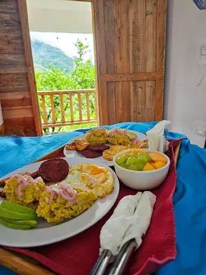 a table with a plate of breakfast food on it at Cabañas en las Montañas in San Cristóbal