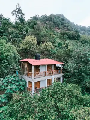 a house with a red roof in the forest at Cabañas en las Montañas in San Cristóbal