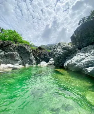 a body of water with rocks and green water at Cabañas en las Montañas in San Cristóbal