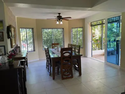 a dining room with a table and chairs and a ceiling fan at La Cigua in Pedro Brand