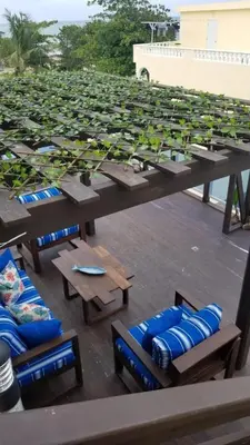 a group of picnic tables and blue chairs on a roof at Vamar Apartamentos in San Felipe de Puerto Plata