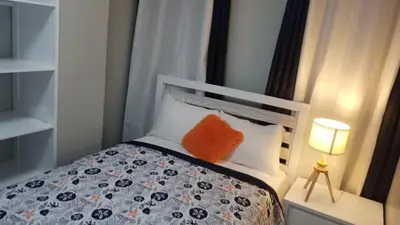 a small bedroom with a bed with an orange pillow at Vamar Apartamentos in San Felipe de Puerto Plata