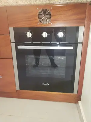 a black oven in a wooden cabinet at Vamar Apartamentos in San Felipe de Puerto Plata