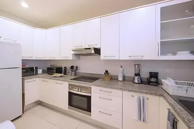a white kitchen with white cabinets and appliances at Club Hemingway Amplio Apartamento en la Playa de Juan Dolio in Los Corrales