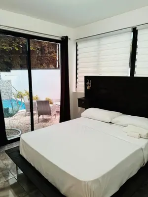 a bedroom with a large bed and a large window at El Rincon Soleado in San Felipe de Puerto Plata