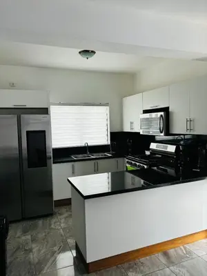 a kitchen with white cabinets and a white counter top at El Rincon Soleado in San Felipe de Puerto Plata