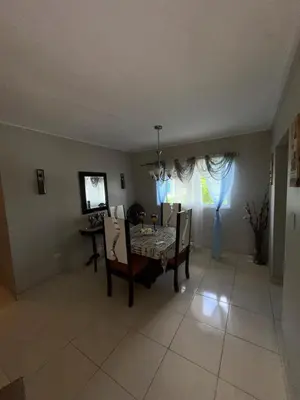 a dining room with a table and chairs and a window at La Romana Caleta Apartment in La Romana