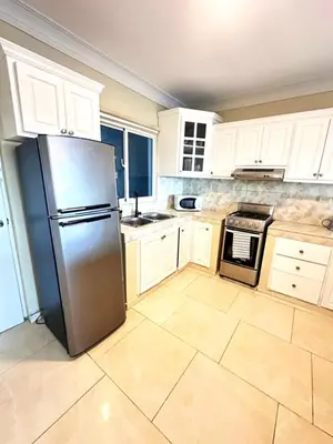 a kitchen with white cabinets and a stainless steel refrigerator at Itzayana 1 in Las Terrenas