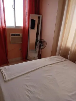 a bedroom with a white bed and a mirror at Dona Beba Guesthouse in La Caleta