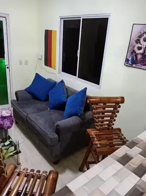 a living room with a gray couch and blue pillows at Dona Beba Guesthouse in La Caleta