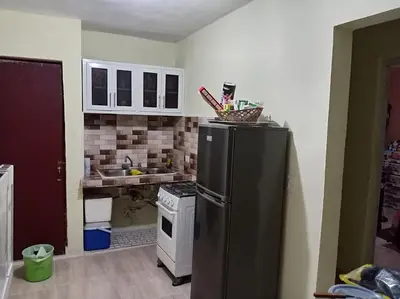 a kitchen with a black refrigerator and a stove at Dona Beba Guesthouse in La Caleta