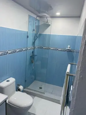 a bathroom with a toilet and a glass shower at Apartamento en el Batey de Sosua in Sosúa