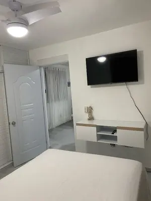 a bedroom with a bed and a flat screen tv on the wall at Apartamento en el Batey de Sosua in Sosúa