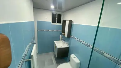 a blue and white bathroom with a toilet and a sink at Apartamento en el Batey de Sosua in Sosúa