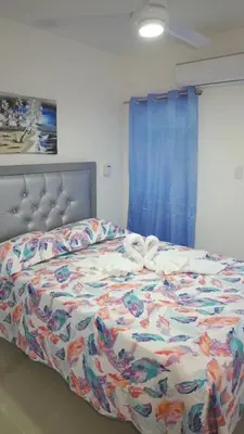 a bedroom with a bed with a comforter with a bow on it at Elida Oceanfront Rentals in Sampiño