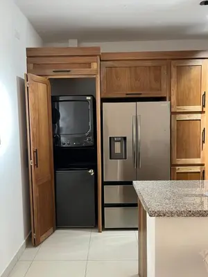 a kitchen with a refrigerator and a tv at GH Condos by Sunrise1 in San Felipe de Puerto Plata