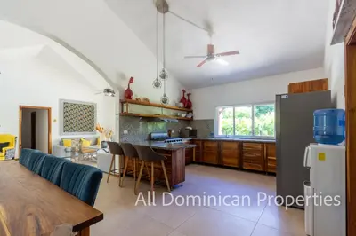 a living room and kitchen with a table and chairs at Sosua Private villa, 9 br, guest friendly, Up to 20 persons! in Sosúa