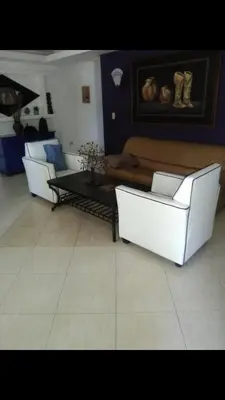 a living room with two white chairs and a table at VILLAS SONJASAA LOFt in Baní