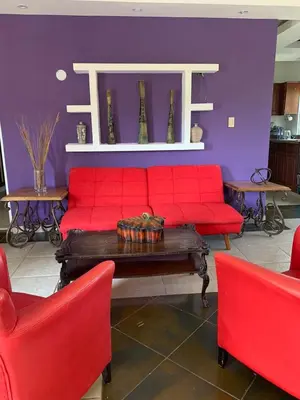 a living room with a red couch and two red chairs at VILLAS SONJASAA LOFt in Baní