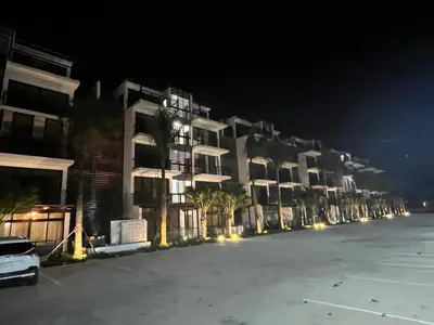 a row of apartment buildings at night with a parking lot at GH Condos by Sunrise2 in San Felipe de Puerto Plata