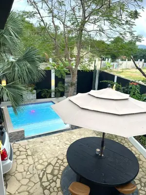 a umbrella sitting on a table next to a pool at Santa's Villa Punta Rucia in Punta Rucia