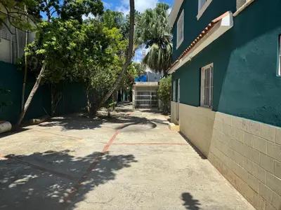 a side walk next to a blue building with a tree at Solano Apartamentos in Boca Chica