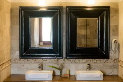 two sinks in a bathroom with two mirrors at Penthouse beach front in Las Terrenas