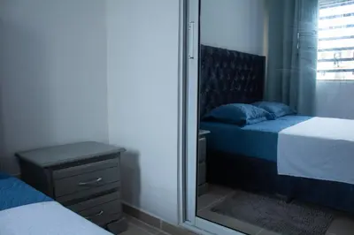 a bedroom with two beds and a mirror at Apartamento tranquilo y cómodo in La Javilla