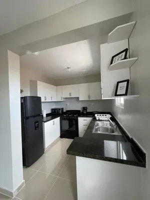 a kitchen with white cabinets and a black refrigerator at 3 bedroom apartment with private jacuzzi and terrace in Ensanche Savica de Mendoza