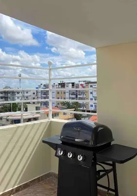 a grill on a balcony with a view of a city at 3 bedroom apartment with private jacuzzi and terrace in Ensanche Savica de Mendoza
