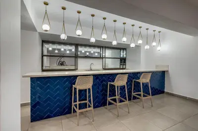 a kitchen with a counter with stools and a sink at Luxury apt city views in the center of the city in Santo Domingo