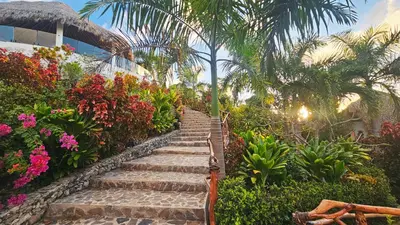 a set of stone stairs in a garden with flowers at Araya Resort in Las Galeras