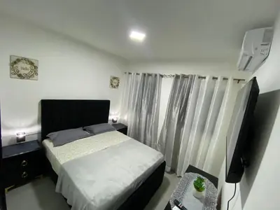 a small bedroom with a bed and a television at Apartamento en Higuey City Home in Higuey