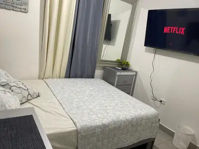a bedroom with a bed and a tv on the wall at Apartamento en Higuey City Home in Higuey