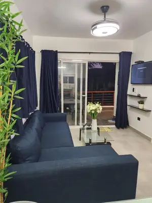 a living room with a blue couch and a window at Villa Victoria in Sosúa
